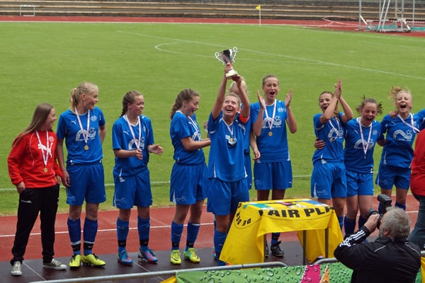 Næsbys U15-piger løfter pokalen efter 6-1-sejren over Marienlyst på Odense Atletikstadion.
